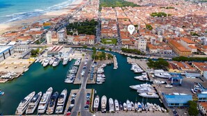A marina with numerous boats docked, a coastal cityscape with buildings, and a beach in the background. - La Suite 2 Ondina Viareggio 200m from sea (Viareggio)