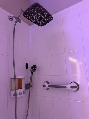 Een bad/douchecombinatie, een haardroger, handdoeken, zeep
