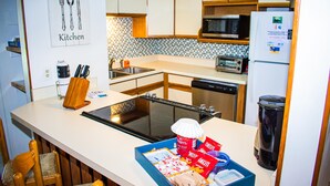 Eine moderne Küche mit Mikrowelle, Backofen und Geschirrspüler. Ein Spülbecken mit doppelter Armatur und eine Arbeitsplatte mit Toaster und Kaffeemaschine.