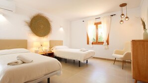 Une chambre d’hôtel avec deux lits, une commode en bois, une chaise et une fenêtre avec des rideaux.