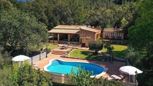 A villa with a swimming pool surrounded by a lush garden and a view of a forested hillside. - Villa Porqueres, Charming house with pool near Pollensa (Pollença)
