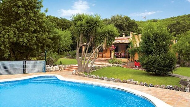 A swimming pool surrounded by a stone deck, with a house and lush greenery in the background. - Villa Porqueres, Charming house with pool near Pollensa (Pollença)