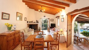Uma sala de estar acolhedora com lareira, móveis de madeira e vista para uma piscina ao ar livre.