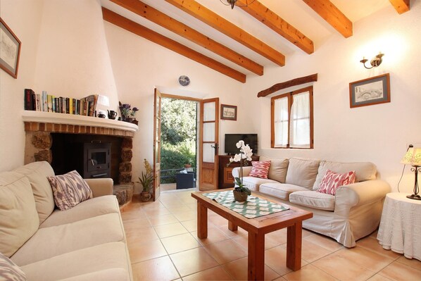 A cozy living room with a fireplace, a sofa, a coffee table, and a television.