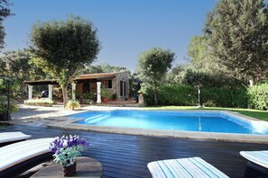 A swimming pool with lounge chairs, a small building, and surrounding greenery. - Villa Can Moranta, Complete peace-of-mind among woods (Pollença)