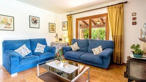 A living room with two blue sofas, a glass coffee table, and a wooden cabinet. - Villa Sol Roma, 3 bedrooms villa  with pool near Pollensa (Pollença)