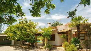A rustic building with a tiled roof, surrounded by greenery and a gravel driveway. - Villa Sol Roma, 3 bedrooms villa  with pool near Pollensa (Pollença)