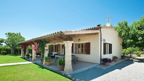 A single-story house with a patio, potted plants, and a clear sky. - Villa Burgues, Idyllic location affording beautiful views. Alcudia (Alcúdia)