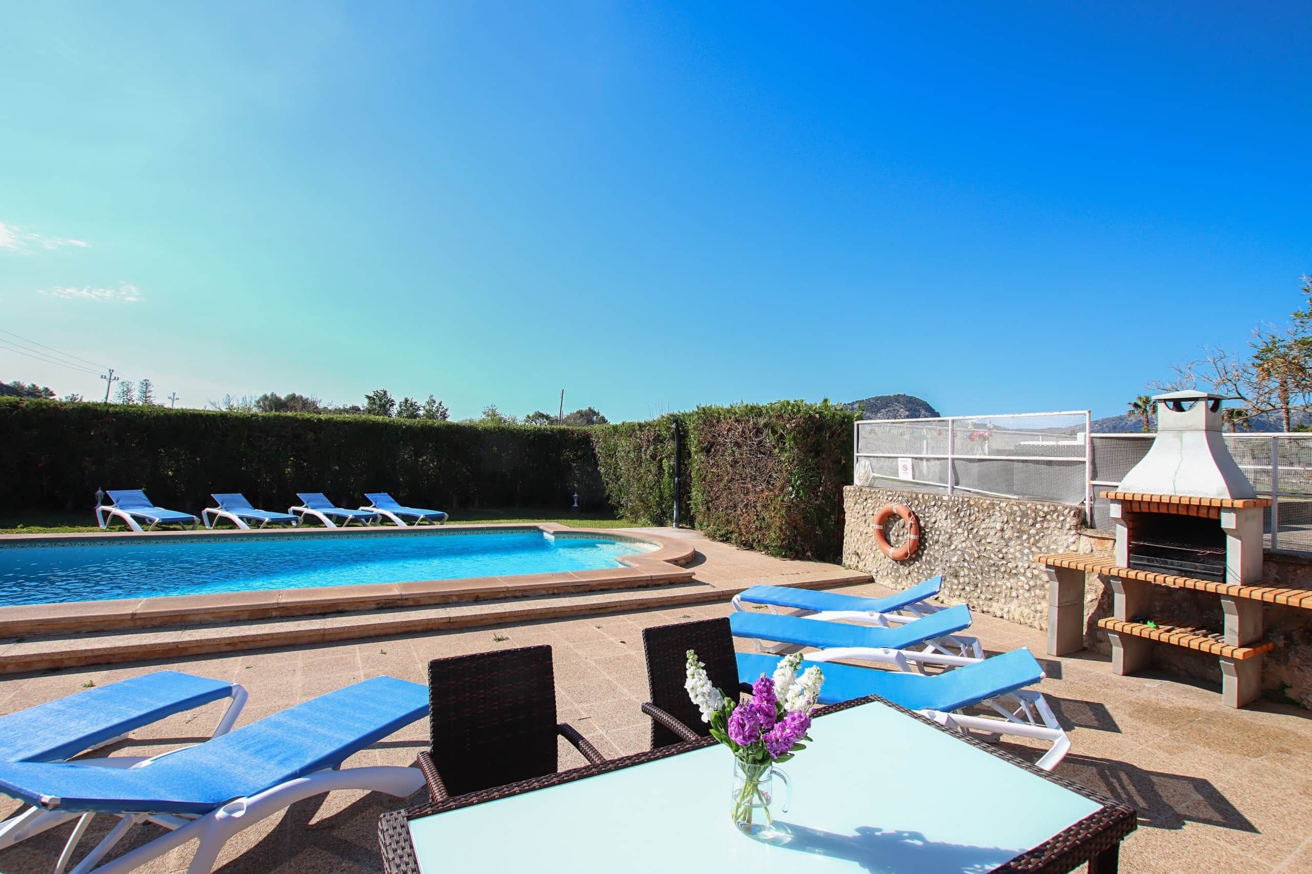 A pool area with lounge chairs and a barbecue grill.