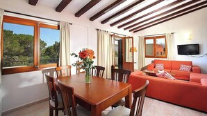A room with a dining table, chairs, a sofa, and a TV. - Villa Animeta, Hermosa villa cerca de Port Pollensa (Pollença)