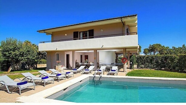 A two-story building with a swimming pool, sun loungers, and a covered patio area. - Villa Animeta, Hermosa villa cerca de Port Pollensa (Pollença)