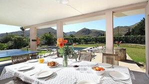 An outdoor dining area with tables set for breakfast, surrounded by mountains and greenery. - Villa Animeta, Hermosa villa cerca de Port Pollensa (Pollença)