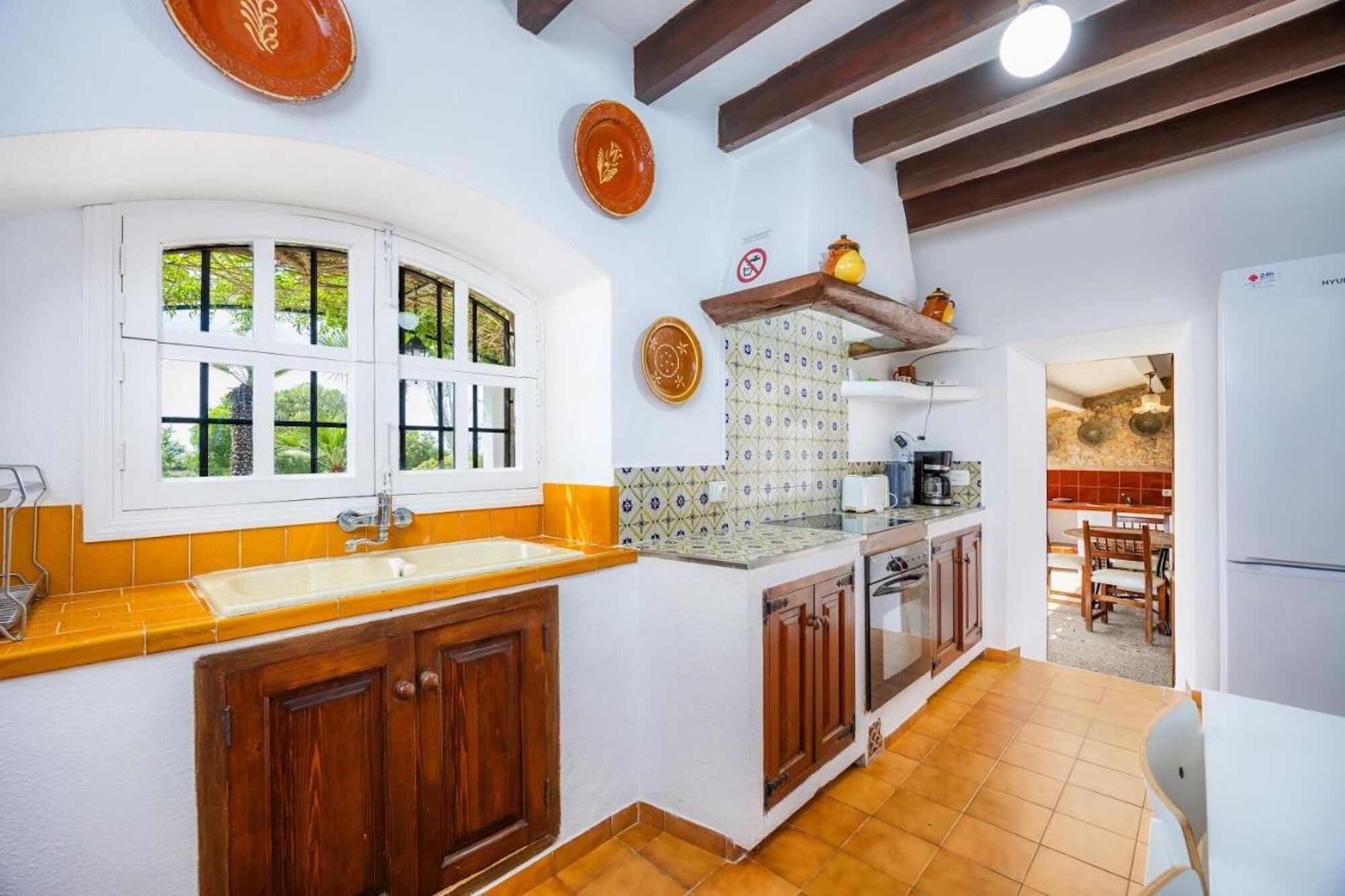 A kitchen with wooden cabinets, a sink, and a window with multiple panes.