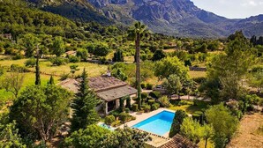 A villa with a swimming pool surrounded by lush greenery and mountains in the background. - Villa La Plana, Fantastic villa in a very quiet area (Pollença)