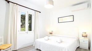 A bedroom with a bed, two bedside tables, a chair, a window with curtains, and a wall-mounted picture. - Villa La Plana, Fantastic villa in a very quiet area (Pollença)