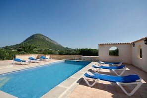 A swimming pool with blue lounge chairs and a mountain in the background. - Villa Varella, Pretty villa close to Pollensa (Pollença)