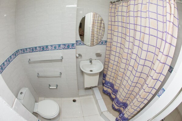 Une salle de bain avec des toilettes, un lavabo et un miroir.