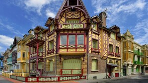 Ein farbenfrohes Gebäude im viktorianischen Stil mit einem markanten Giebel und vielen Fenstern.