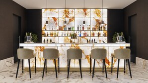 A bar area with a marble countertop, multiple liquor bottles, and three bar stools. - Aurea Ana Palace by Eurostars Hotel Company (Budapest)