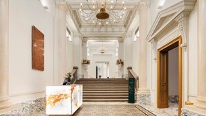 A grand hallway with marble floors, a staircase, and a reception desk. - Aurea Ana Palace by Eurostars Hotel Company (Budapest)
