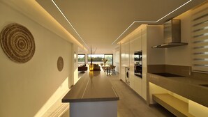 Villa – deluxe | Oppholdsområde | En 75-tommers Flatskjerm-TV med kabel-kanaler samt smart-TV