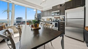 A modern kitchen with a large island, stainless steel appliances, and a view of the city.