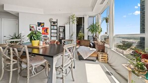 A modern living space with a dining area, seating, and a view of the city.