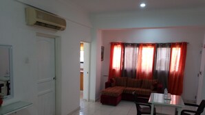 A living room with a sofa, a dining table, and chairs. There is a glass cabinet and a water bottle on the table. - Quiet and comfortable apartment in the center (Santo Domingo)