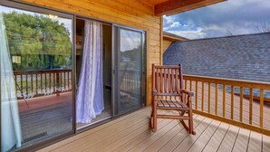 Une terrasse en bois avec une porte-fenêtre coulissante et une chaise en bois.