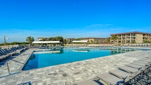 A swimming pool with lounge chairs and a building in the background.