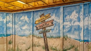 A mural of a beach scene with a signpost indicating 'Jamaica Joez Beach Bar Paradise'.