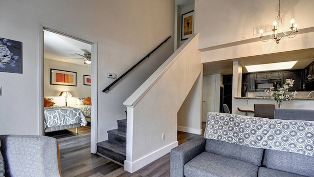 Een moderne woonkamer met een trap, een eethoek en een keuken.