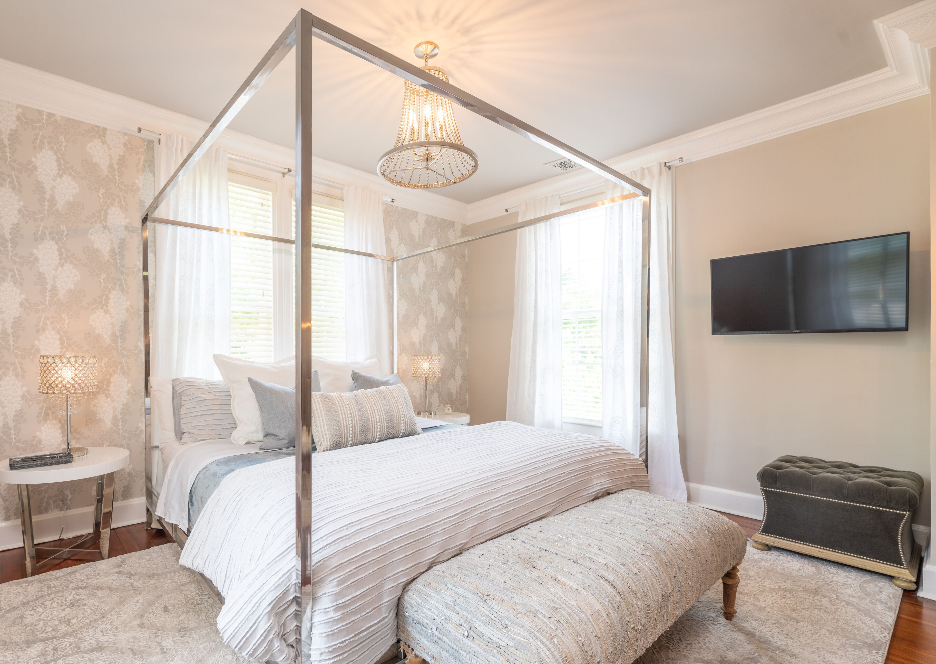 Een hemelbed, een nachtkastje met lamp, een aan de muur bevestigde televisie en een klein voetenbankje.