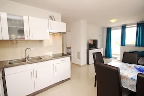 Køleskab, mikrobølgeovn, spisebord