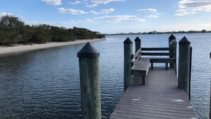 Un muelle de madera que se adentra en aguas tranquilas, con un banco al final.