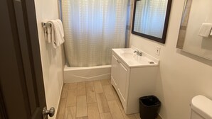 A bathroom with a toilet, sink, and bathtub. - Starlite Motel (Stanton)