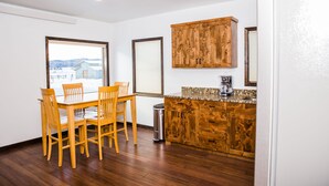 Una cocina con armarios de madera, una mesa de comedor con sillas y vistas a un paisaje nevado a través de una ventana.