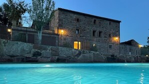 A stone building with a swimming pool in front. - masoveria la boba (Vilanova de la Aguda)