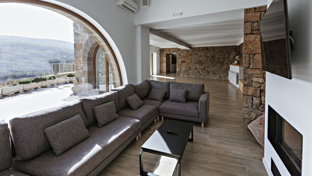 A modern living room with a sectional sofa, a coffee table, and a stone fireplace. - masoveria la boba (Vilanova de la Aguda)