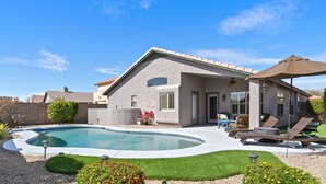 Una casa moderna con piscina, mobiliario exterior y jardín cuidado.