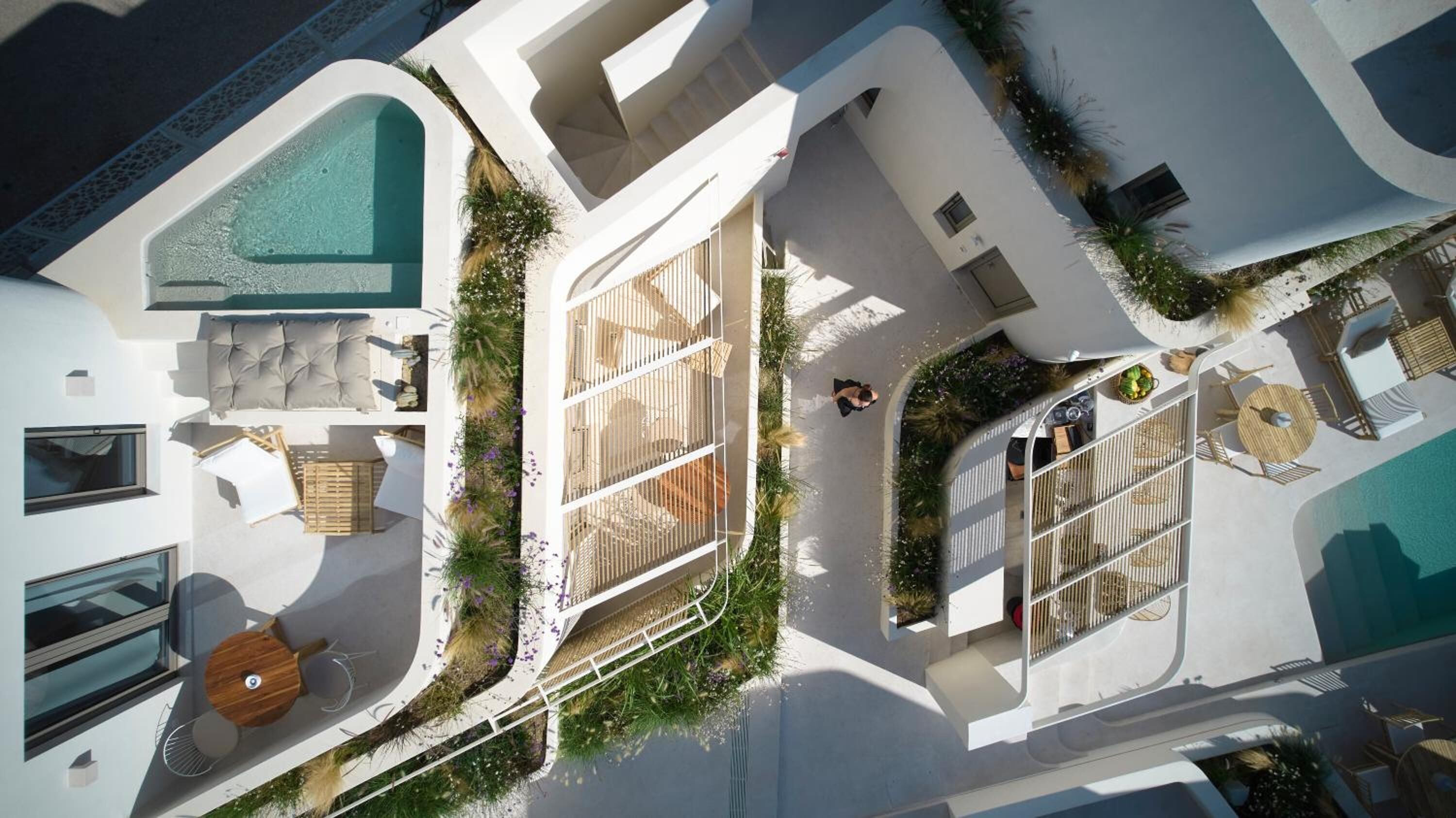 A modern resort with a pool, outdoor seating, and a covered patio area.