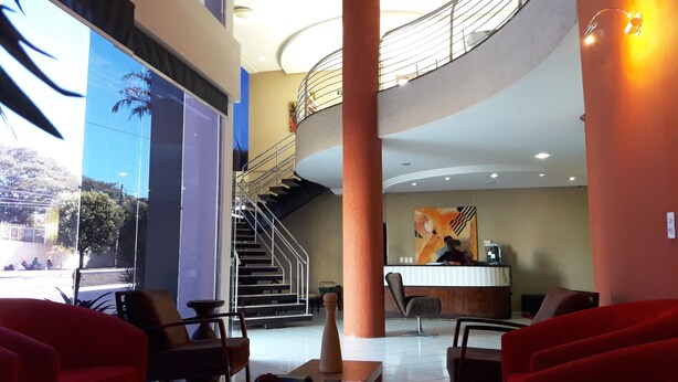 A spacious lobby with a staircase leading to an upper level, a reception desk, and seating areas. - Hotel Colorado (Rio Verde)