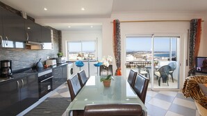 Cocina moderna con comedor, vistas a la ciudad y un balcón con vistas al mar.