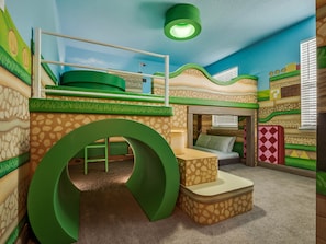 A children's playroom with a bunk bed, a large green play structure, and a window with blinds.