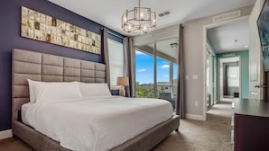Une chambre moderne avec un grand lit, un luminaire au plafond et une vue sur l’extérieur.
