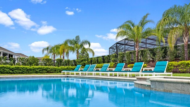 Uma piscina com espreguiçadeiras e palmeiras.