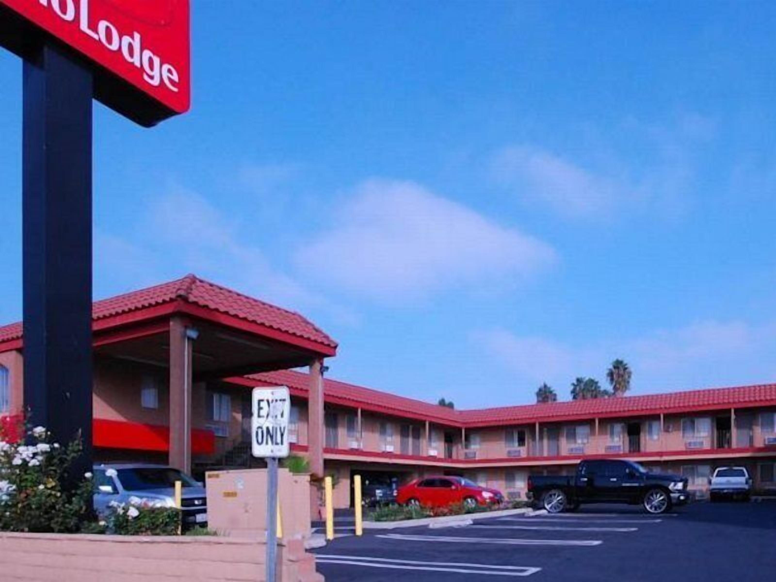 A motel with a red roof and a sign that reads "Exit Only".