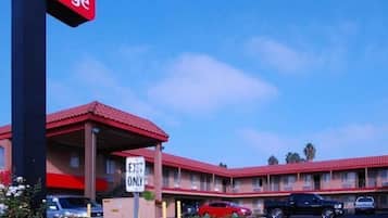 A motel with a red roof and a sign that reads "Exit Only".