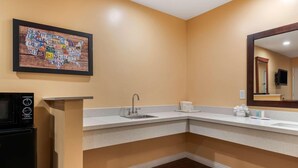 Un baño con lavabo, espejo y un mapa de los Estados Unidos en la pared.