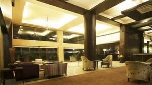 A spacious lobby with high ceilings, large windows, and multiple seating areas. - Jukaso IT Suites (Gurugram)